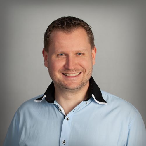 Christian Sachse, Geschäftsführer von xtero, lächelt im hellblauen Hemd vor grauem Hintergrund
